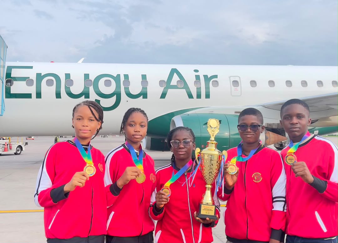 Our team with their trophy in front of an Enugu Air aircraft, travelling to the national finals