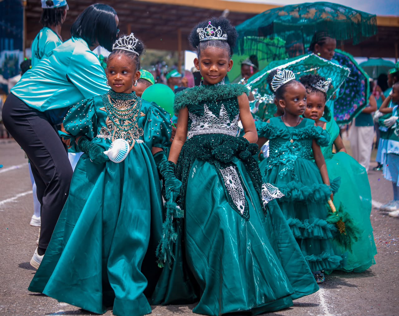 Little girls in emerald gowns and tiaras